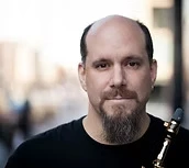 man smiling with saxophone